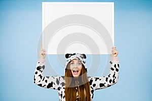 Happy crazy woman in cow costume holding board
