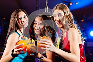 People drinking cocktails in bar or club
