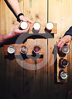 People drinking local beer from tasting palettes at craft brewery photo