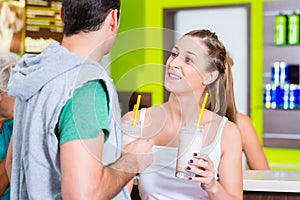 People drinking protein shakes in fitness studio