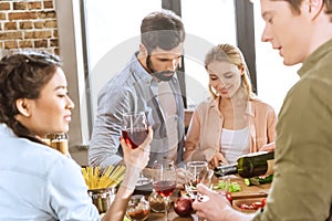 People drinking wine at home party