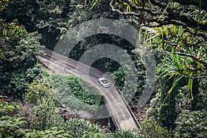 People drive luxury convertible car on scenic tropical road to Hana in Maui, Hawaii