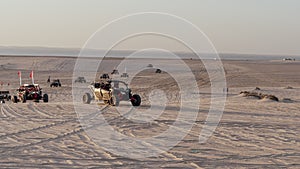 People driving quad bikes on the dunes in sealine