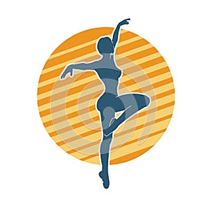 Silhouette of a female ballet dancer in action pose.