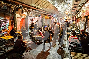 People  eat and drink on a food court in the evening  at the Machane Yehuda Market in Jerusalem, Israel