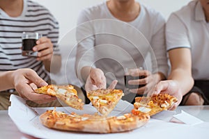 People eat fast food. Friends hands taking slices of pizza