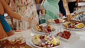 People eat fruits on the party outdoor