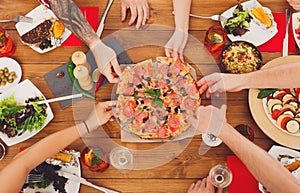 People eat pizza at festive table dinner party