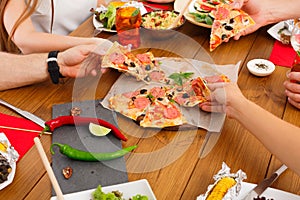 People eat pizza at festive table dinner party