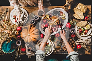 People eating festive dinner on Thanksgiving day with cat