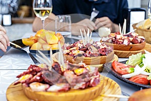 People eating Pulpo a la Gallega with potatoes. Galician octopus photo
