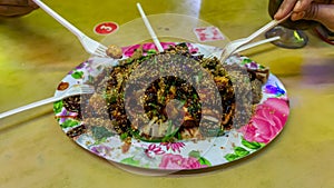 People eating Yong Tau Foo or Yentafu, a Chinese cuisine using plastic fork on a table