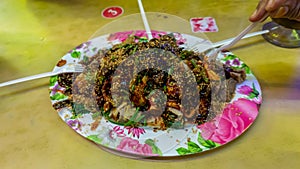 People eating Yong Tau Foo or Yentafu, a Chinese cuisine using plastic fork on a table