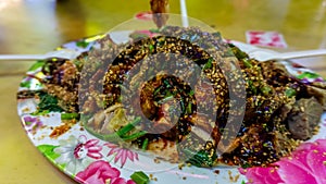 People eating Yong Tau Foo or Yentafu, a Chinese cuisine using plastic fork on a table