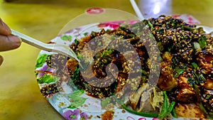 People eating Yong Tau Foo or Yentafu, a Chinese cuisine using plastic fork on a table