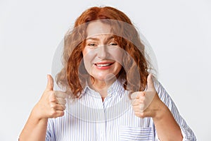 People, emotions and lifestyle concept. Close-up of supportive mother with red hair showing thumbs-up, encourage child