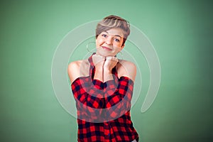 People and emotions - a portrait of smiling woman with short hair keeps hands together and pleads about something