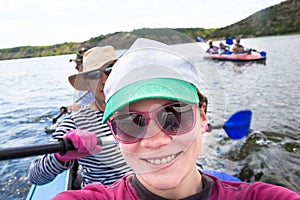 People enjou kayaking on beautiful river. Summer sunny time