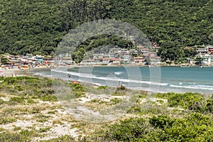 People enjoy the beach at  Florianopolis, with small fishermens village, Brazil