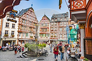 people enjoy the summer day at market place with medival half timbered houses in Bernkastel-Kues