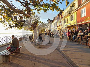 People enjoying afternoon sun on seaside promenade in Meersburg Germany