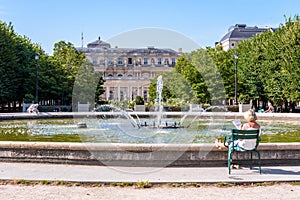 People enjoying the fountain in the Palais-Royal garden in Paris, France