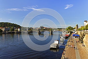 People enjoying nice summer weather at the banks of Vltava river in Prague, Czech republic