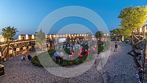 People are enjoying the open air cinema in the hictoric building at evening timelapse