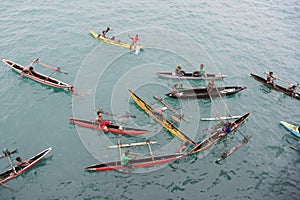 People enjoying rain in canoes on Pacific Ocean