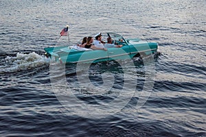 People enjoying ride in vintage red amphicar at Disney Springs 4