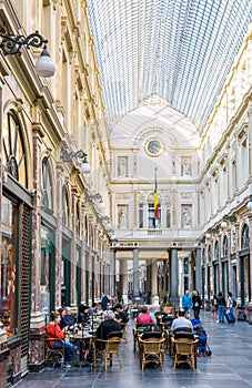 People enjoying the shops and sidewalk cafes in the Saint-Hubert Royal Galleries in Brussels, Belgium