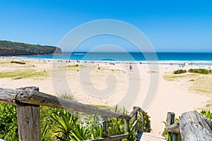 People enjoying the sunny weather at Pebbly Beach, a popular camping area with great surfing beach and bush walks within