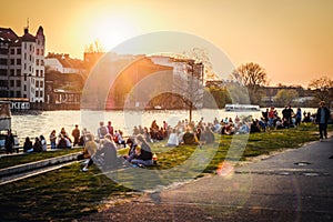 People enjoying sunset at river next to the Berlin Wall / East Side Gallery  in Berlin, Germany