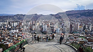 people enjoying the view of a large city from a lookout point photo