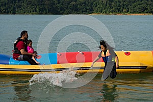 People enjoying water activities on banana boat at the Kenyir Lake, Terengganu, Malaysia