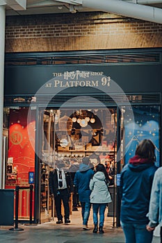 People entering Harry Potter shop by 9 three quarters platform inside King`s Cross station, London, UK