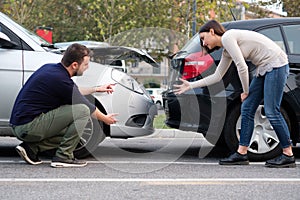 People examining car body damages after car hit