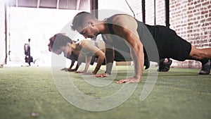 People, exercise and class push ups for workout fitness in gym for sports, athlete practice or cardio. Man, woman and