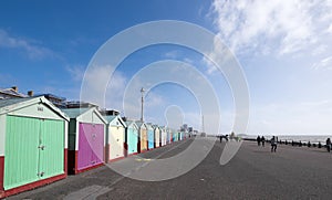 People exercising on Hove seafront near Brighton, UK, with colourful beach huts