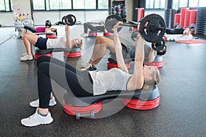 People exercising with weights at gym club