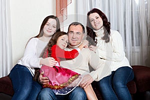 People family, christmas and adoption concept - happy mother, father and children hugging near a Christmas tree at home