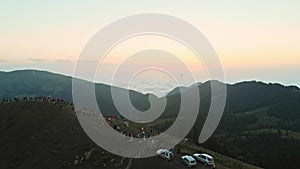 People on famous Bakhmaro sunset viewpoint watch sunset over clouds in Georgia