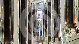 People on fast moving escalator in shopping mall time-lapse view from above