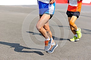 People feet on city road in marathon running race