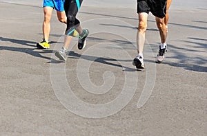 People feet on city road in marathon running race