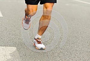 People feet on city road in marathon running race