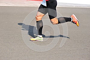 People feet on city road in marathon running race