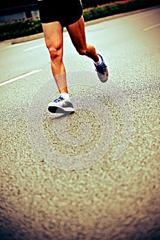 People feet on city road in marathon running race