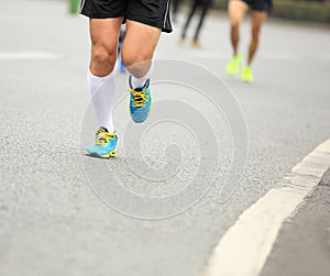 People feet on city road in marathon running race