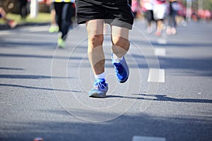 People feet on city road in marathon running race